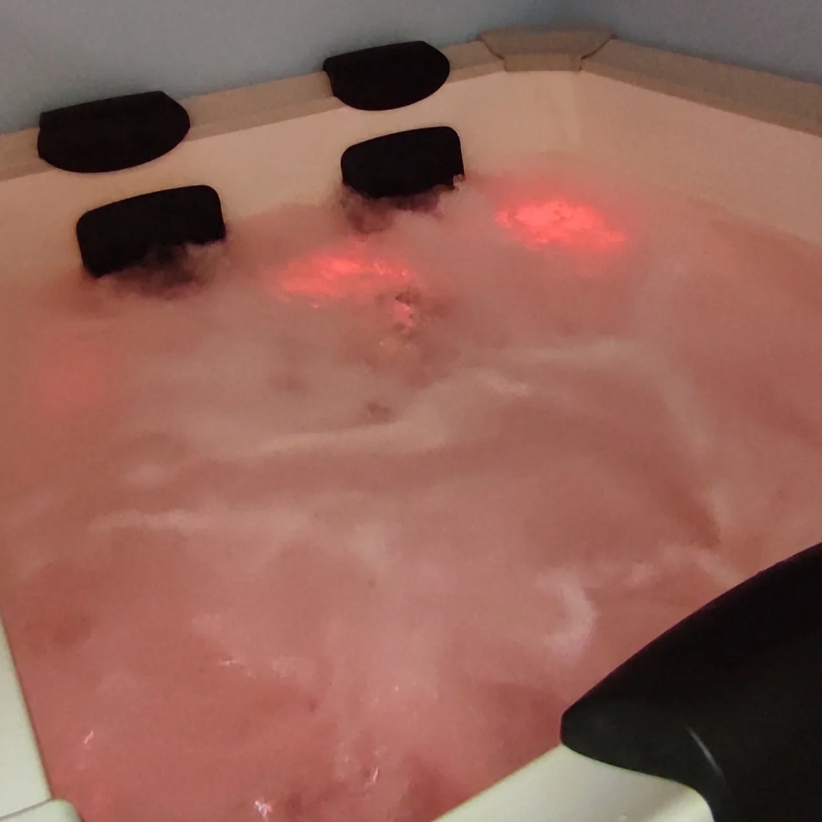 Jacuzzi intérieur en fonctionnement, lumière tamisée